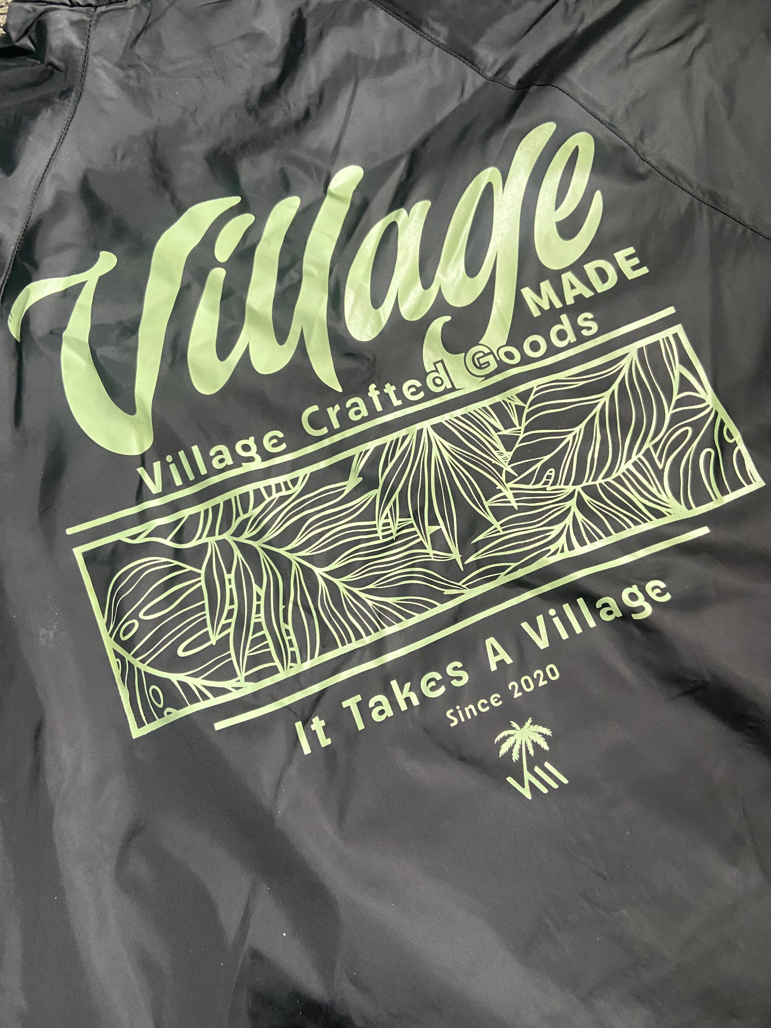 Black jacket with green text and graphics on a dark background